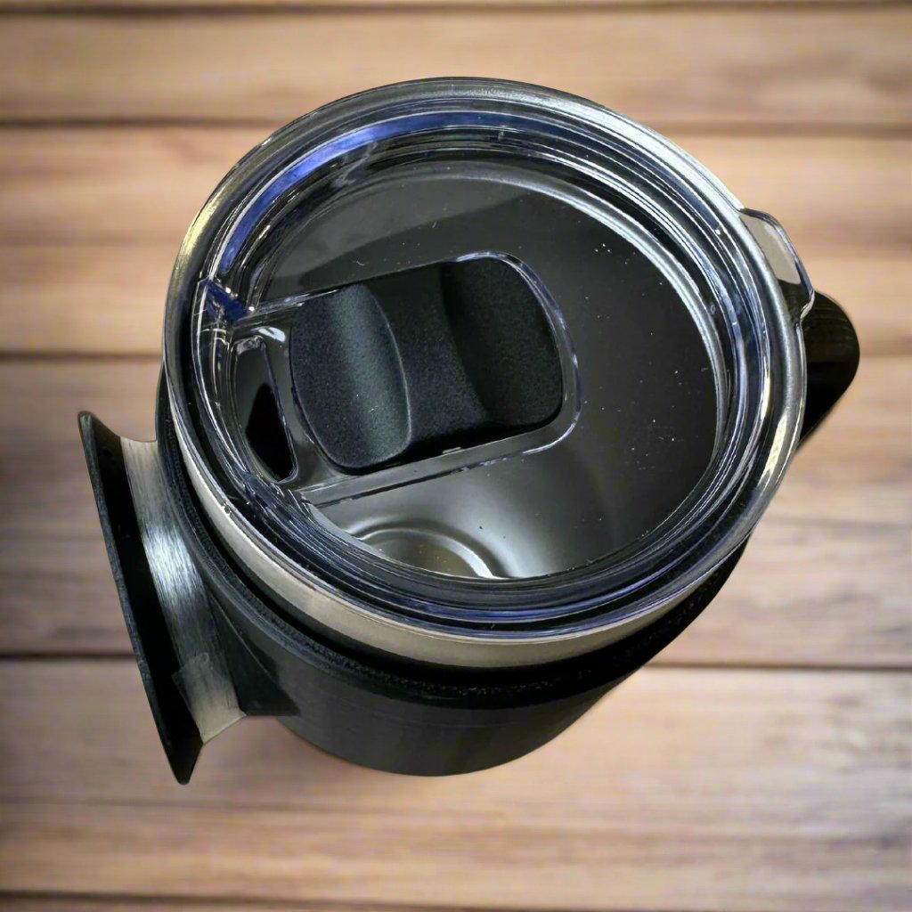 A top view of the Chill-N-Reel® Tumbler Handle (Prototype) combined with a 30oz tumbler, featuring a stainless steel design and transparent plastic lid with sliding closure. Positioned on a wooden surface, this setup highlights its stylish, contemporary look and practical features tailored for every angler's journey.