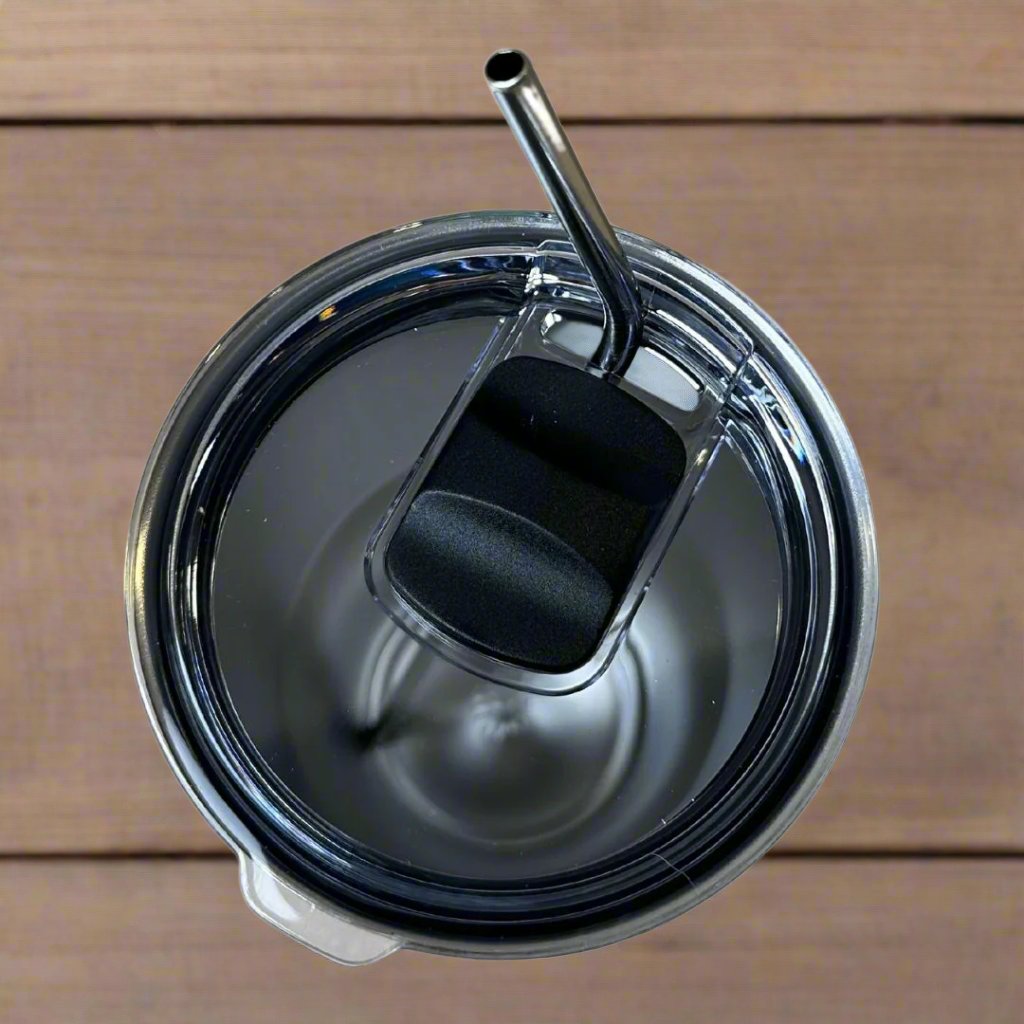 Top view of the 30oz Stainless Steel Vacuum Insulated Tumbler by Chill-N-Reel®, showcasing its closed lid and an elegant stainless steel straw. The tumbler is stylishly placed on a wooden surface.