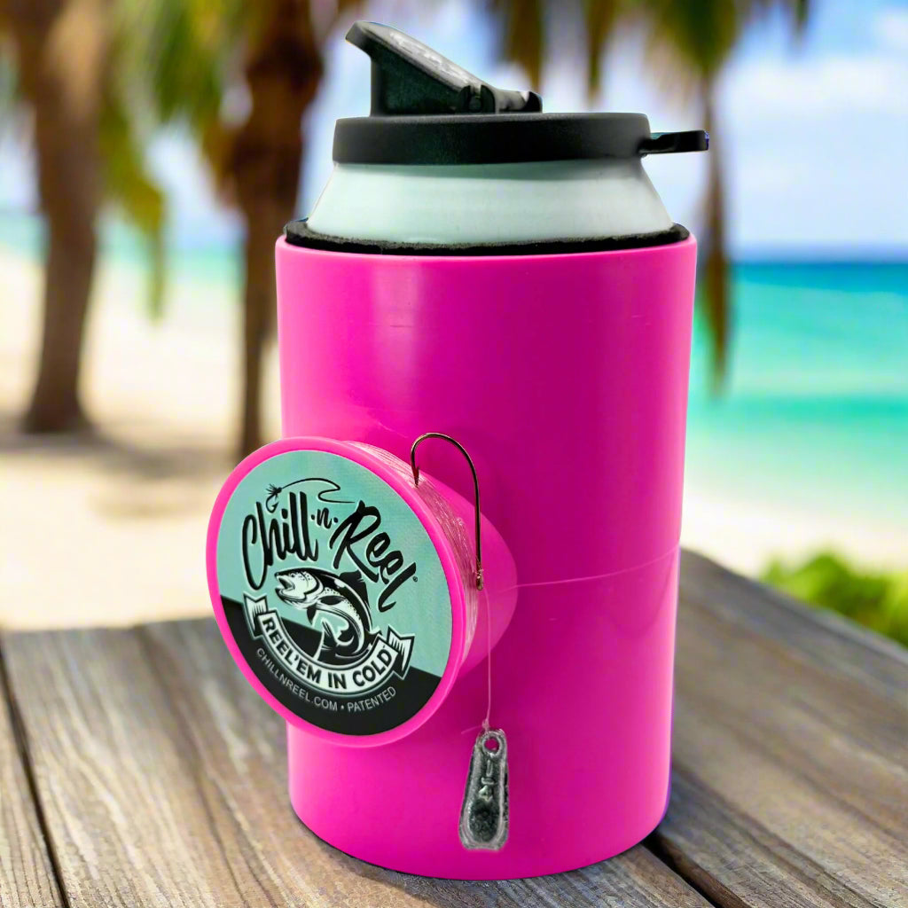 The Original Chill-N-Reel by Chill-N-Reel, a pink can cooler with a built-in hand-line fishing reel, sits on a table with palm trees and ocean views—a fun fishing gift for any angler.