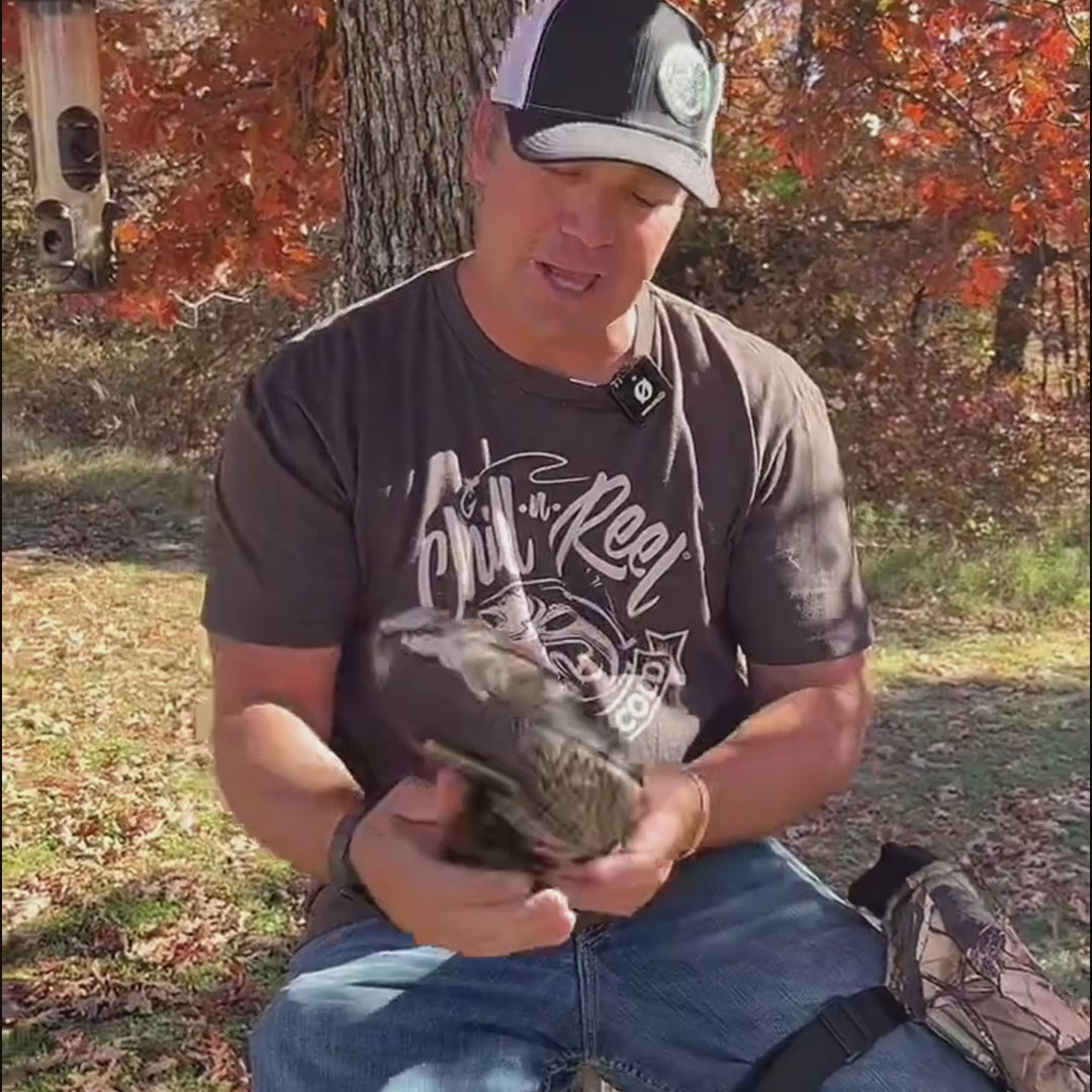 Load video: In the video, Jake introduces Stand Mitts for cold weather hunting and fishing. These mittens strap to your leg or stand, keeping hands warm and ready without spooking game. They have insulation, space for snacks and a phone, and are perfect for ice fishermen, hunters, and sports fans.